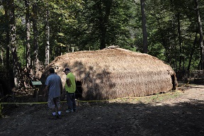 Some visitors examining one of the long houses